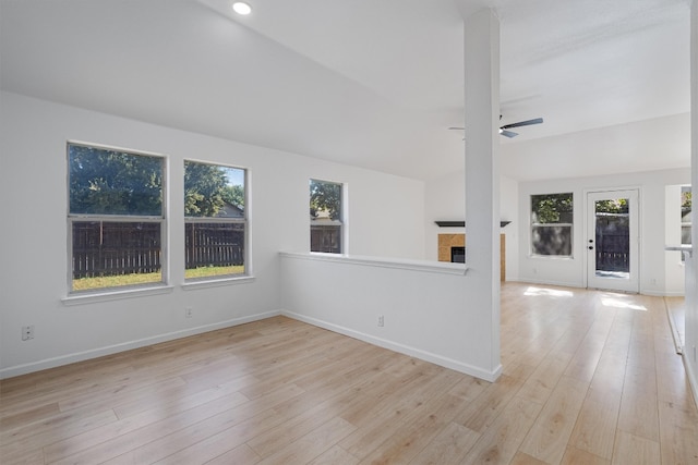 unfurnished living room with ceiling fan, light wood-type flooring, and lofted ceiling