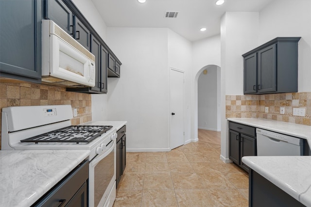 kitchen featuring backsplash, white appliances, and light tile patterned floors