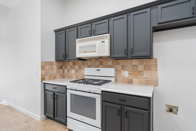 kitchen with gray cabinets, backsplash, and white appliances