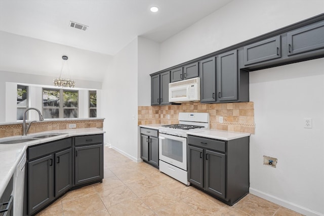 kitchen with tasteful backsplash, a notable chandelier, hanging light fixtures, vaulted ceiling, and white appliances