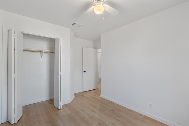 unfurnished bedroom featuring light hardwood / wood-style flooring, ceiling fan, and a closet