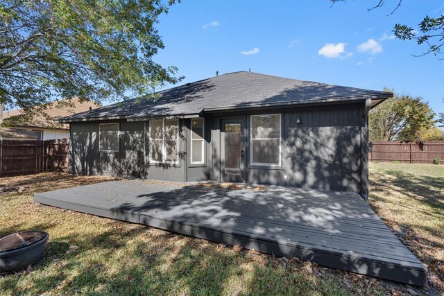 rear view of house with a wooden deck and a yard