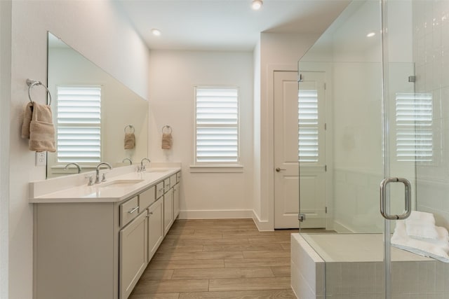 bathroom with walk in shower, vanity, and hardwood / wood-style flooring