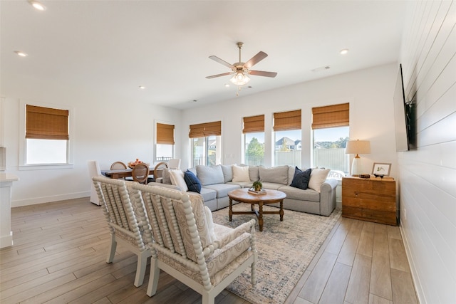 living room featuring light wood-type flooring, ceiling fan, and plenty of natural light