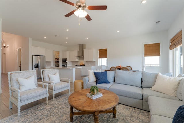 living room featuring ceiling fan and light hardwood / wood-style flooring