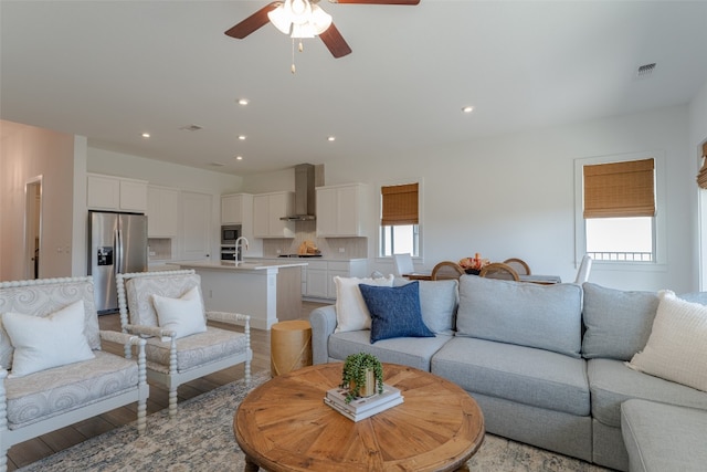 living room with ceiling fan, light hardwood / wood-style floors, and a healthy amount of sunlight