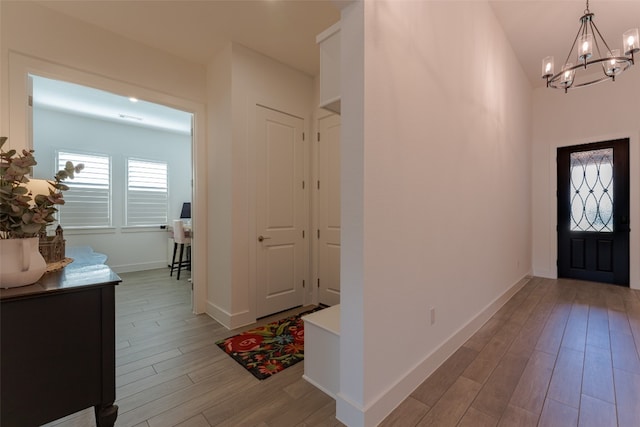 entrance foyer with light hardwood / wood-style floors and an inviting chandelier