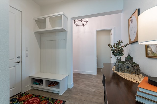 mudroom with an inviting chandelier and hardwood / wood-style floors