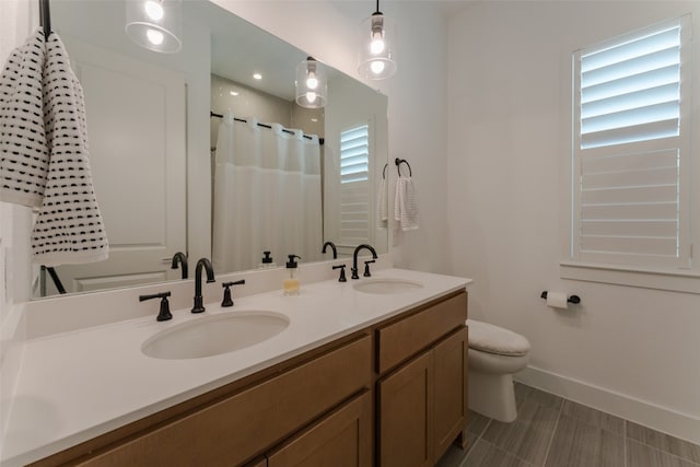 bathroom with walk in shower, vanity, and toilet