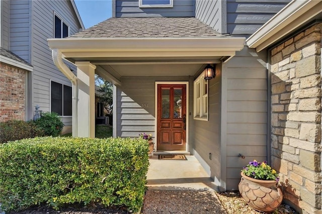 doorway to property with roof with shingles