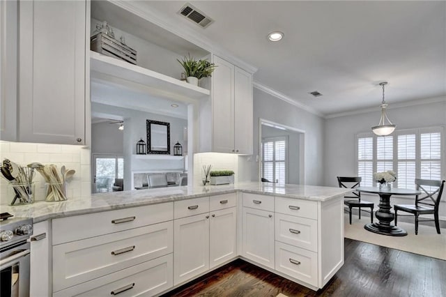 kitchen with white cabinets, kitchen peninsula, dark hardwood / wood-style floors, crown molding, and pendant lighting