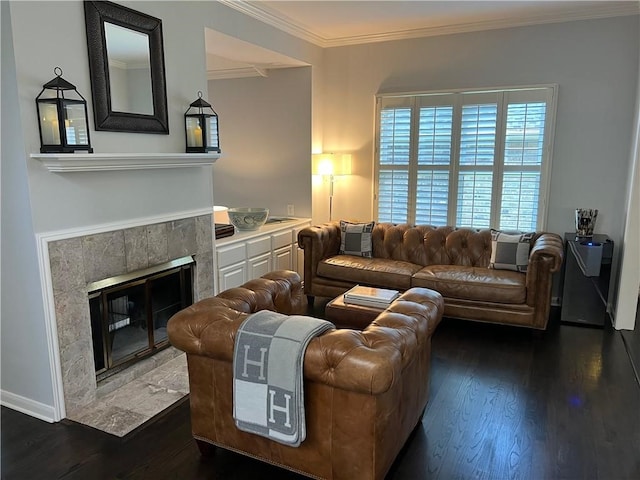 living room with dark wood-type flooring, a tile fireplace, and ornamental molding