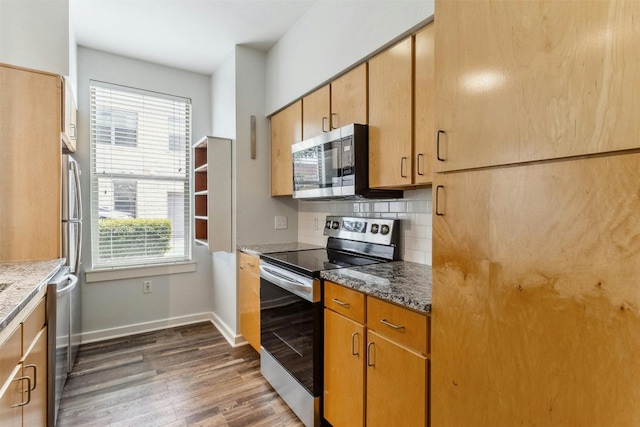1201 Grove Blvd Unit 1501, Austin, TX 78741 - kitchen featuring stainless steel appliances, dark wood finished floors, dark stone countertops, and decorative backsplash