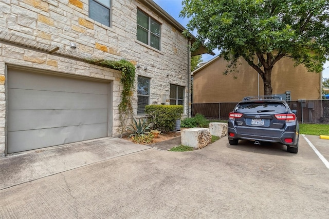 1201 Grove Blvd Unit 1501, Austin, TX 78741 - view of front of home featuring stone siding, fence, and driveway