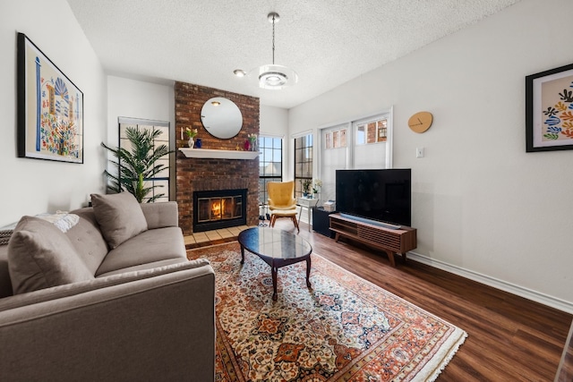 living room featuring a textured ceiling, hardwood / wood-style flooring, and a fireplace