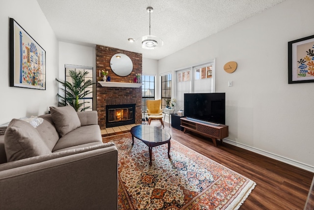 3001 Cedar St Unit 310, Austin, TX 78705 - living area with dark wood finished floors, a brick fireplace, and a textured ceiling