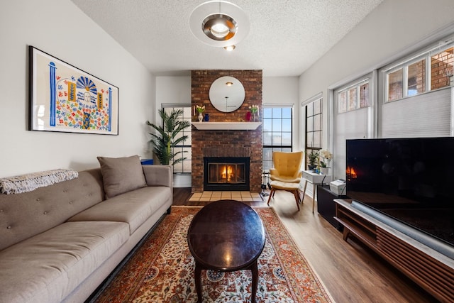 living room with a fireplace, wood-type flooring, and a textured ceiling