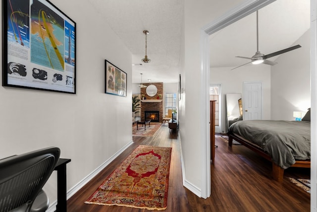 interior space with a textured ceiling, a fireplace, dark hardwood / wood-style flooring, and ceiling fan