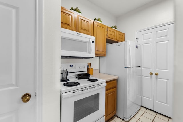 kitchen with light tile patterned floors and white appliances