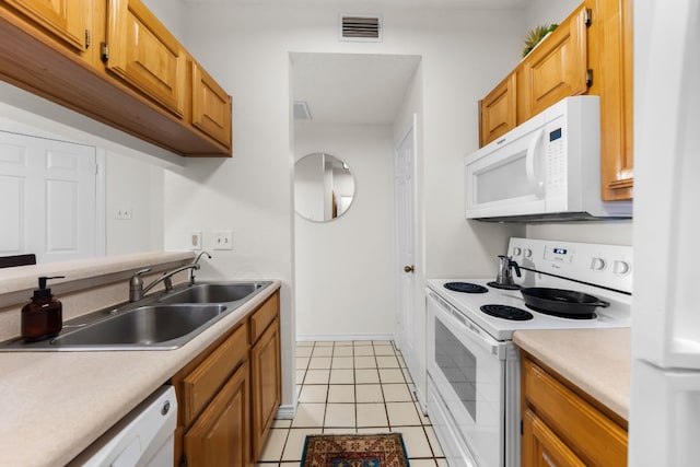 3001 Cedar St Unit 310, Austin, TX 78705 - kitchen featuring white appliances, light countertops, light tile patterned flooring, and brown cabinetry