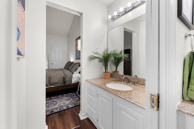 3001 Cedar St Unit 310, Austin, TX 78705 - ensuite bathroom with wood finished floors, vanity, and vaulted ceiling