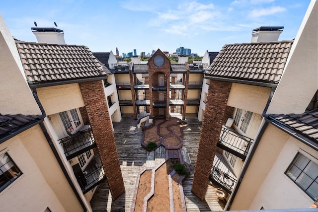 3001 Cedar St Unit 310, Austin, TX 78705 - exterior view of a tile roof, a chimney, a view of city, and stucco siding