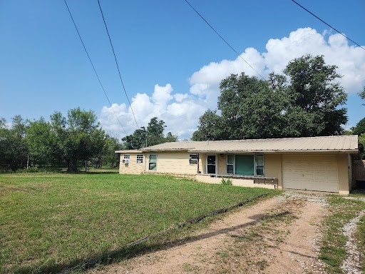 ranch-style house with a garage and a front yard