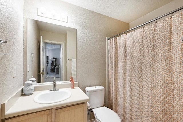 bathroom featuring walk in shower, vanity, toilet, and a textured ceiling