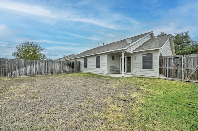 back of house featuring a patio and a lawn