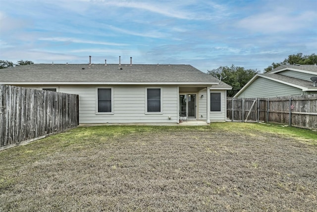 rear view of property featuring a yard