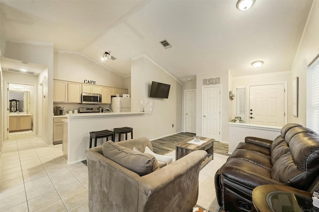 living room featuring lofted ceiling and light tile patterned floors