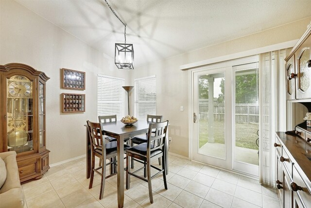 dining area with light tile patterned floors and a chandelier