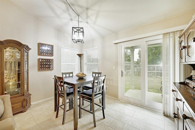 dining room with light tile patterned floors and a chandelier