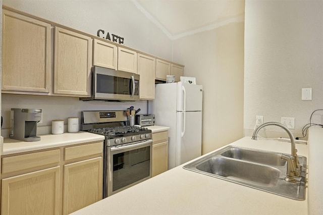 kitchen featuring stainless steel appliances, lofted ceiling, sink, and light brown cabinets