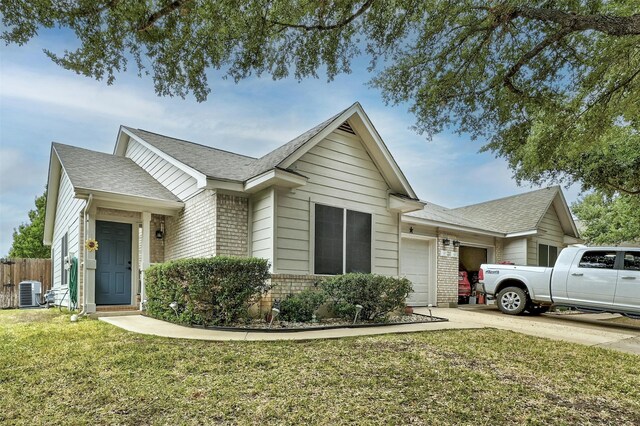 single story home with a garage, central AC, and a front yard