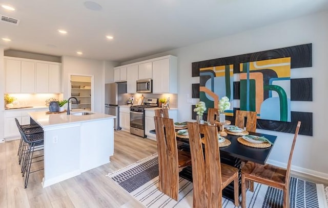 dining space with sink and light hardwood / wood-style flooring