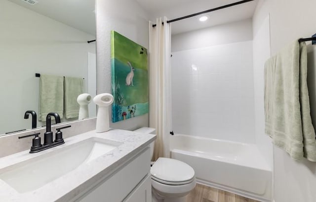 full bathroom with vanity, hardwood / wood-style flooring,  shower combination, and toilet