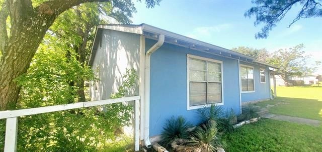 view of side of property with a lawn