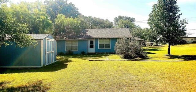 exterior space featuring a front lawn and a storage shed