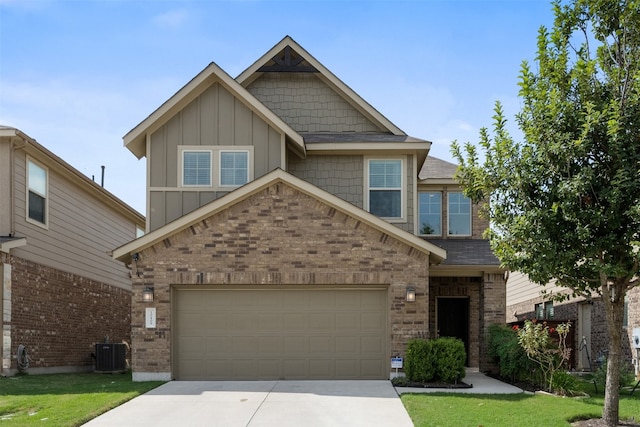 craftsman-style home with central air condition unit, a front yard, and a garage