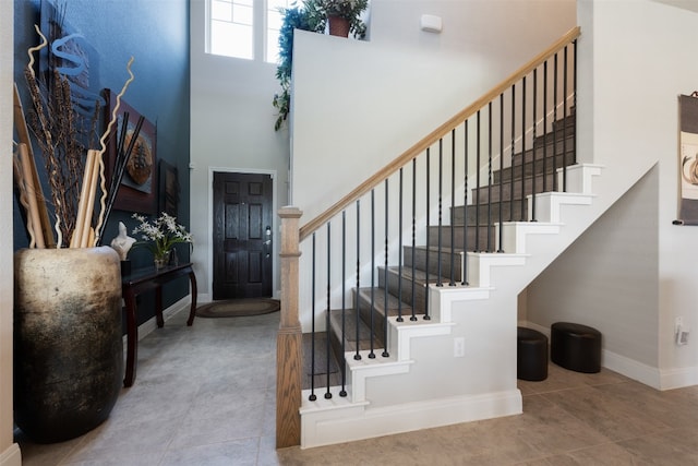 entrance foyer with a towering ceiling and tile patterned flooring