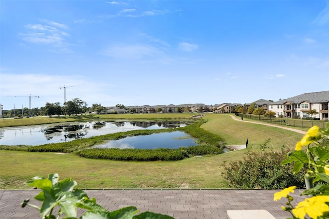 surrounding community featuring a lawn and a water view