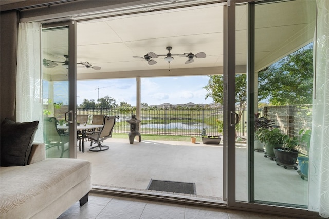 doorway to outside featuring ceiling fan and a water view