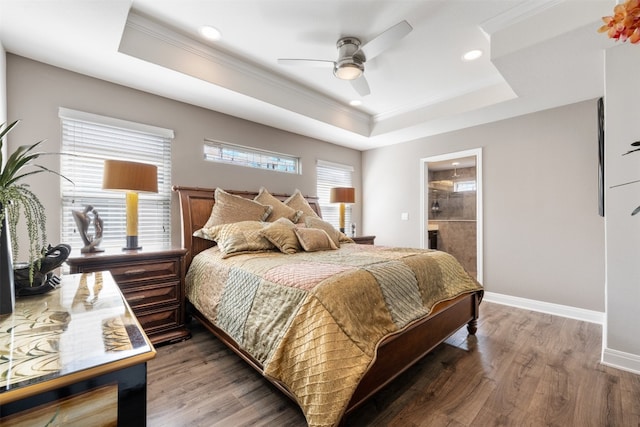 bedroom featuring ensuite bath, dark wood-type flooring, ceiling fan, crown molding, and a raised ceiling