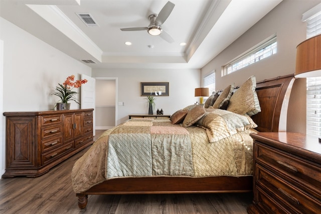 bedroom featuring ornamental molding, ceiling fan, a tray ceiling, and dark hardwood / wood-style floors