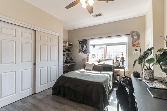 bedroom with ceiling fan, dark hardwood / wood-style floors, and a closet