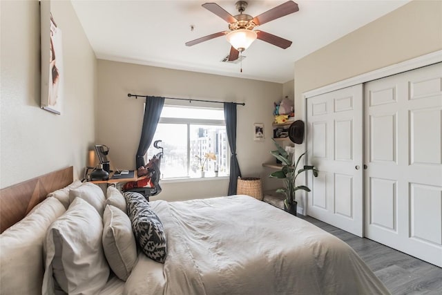 bedroom featuring dark wood-type flooring, ceiling fan, and a closet