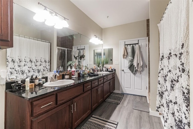 bathroom featuring walk in shower, vanity, and hardwood / wood-style flooring