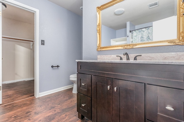 bathroom with hardwood / wood-style floors, vanity, and toilet