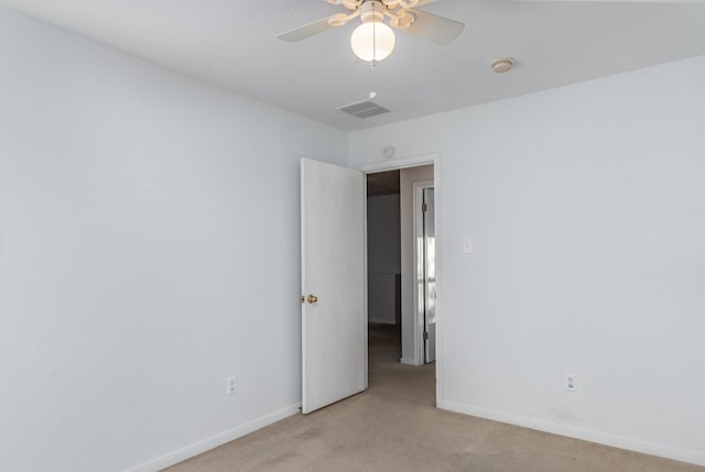 unfurnished room featuring light carpet and ceiling fan